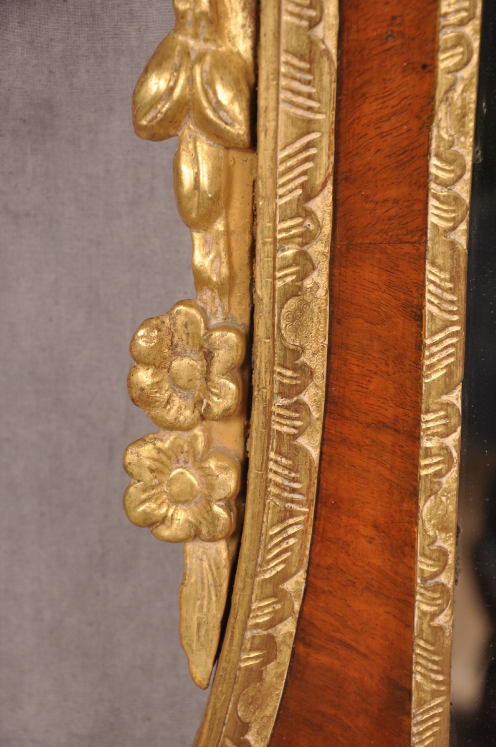 An 18th-century walnut and parcel gilt wall mirror featuring a carved swan-neck pediment, central cartouche crest, and floral side pendants. View VIII