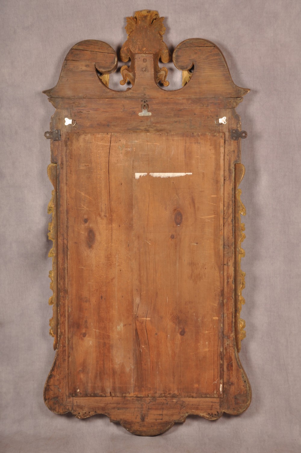 An 18th-century walnut and parcel gilt wall mirror featuring a carved swan-neck pediment, central cartouche crest, and floral side pendants. View XIII
