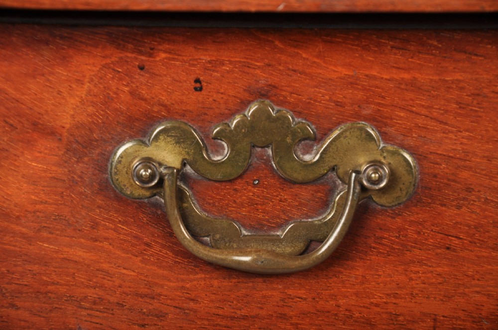 An 18th-century mahogany kneehole desk featuring multiple drawers with brass swan-neck handles, a central recessed cupboard, and bracket feet. View II