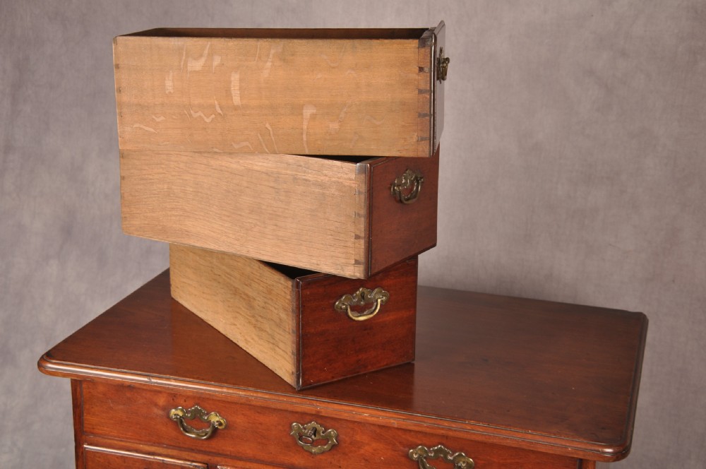 An 18th-century mahogany kneehole desk featuring multiple drawers with brass swan-neck handles, a central recessed cupboard, and bracket feet. View X