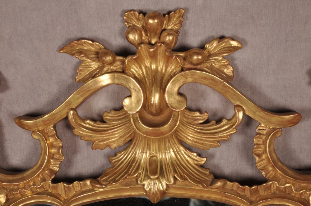 An ornate late nineteenth-century giltwood wall mirror featuring carved acanthus leaf scrollwork and an arched mirror plate. View III