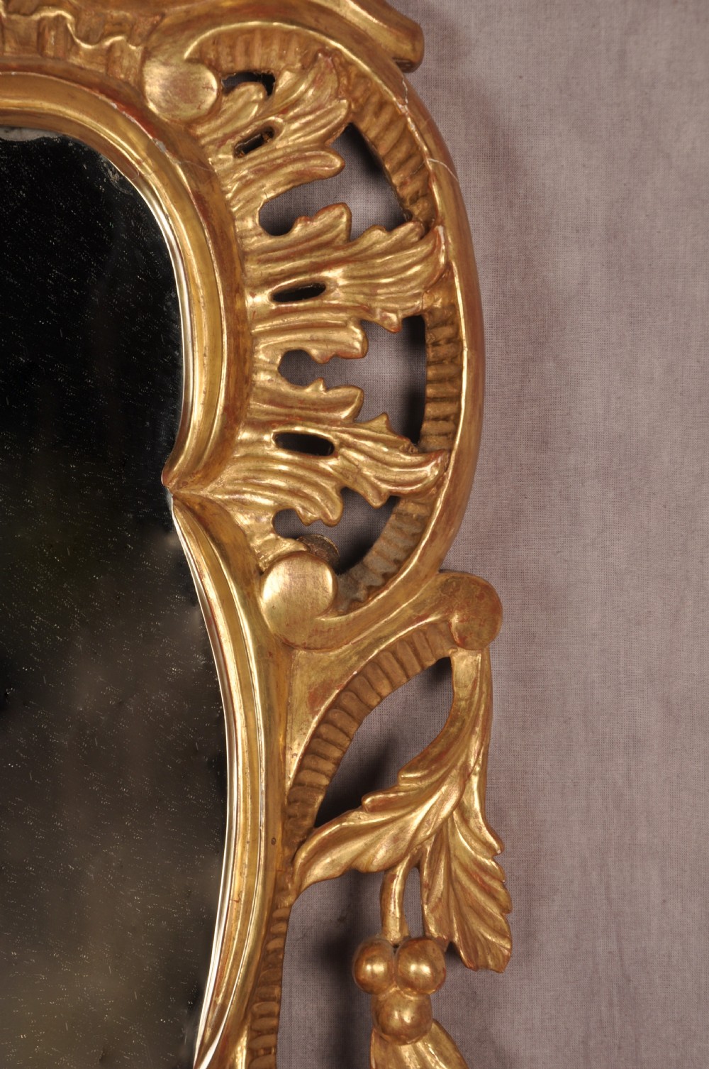 An ornate late nineteenth-century giltwood wall mirror featuring carved acanthus leaf scrollwork and an arched mirror plate. View IV