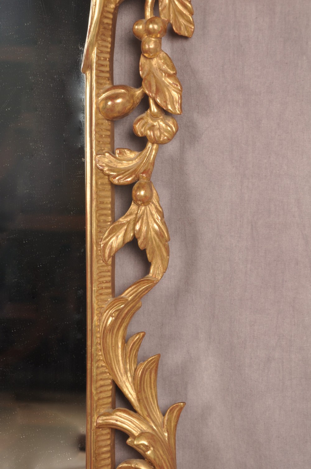 An ornate late nineteenth-century giltwood wall mirror featuring carved acanthus leaf scrollwork and an arched mirror plate. View VI