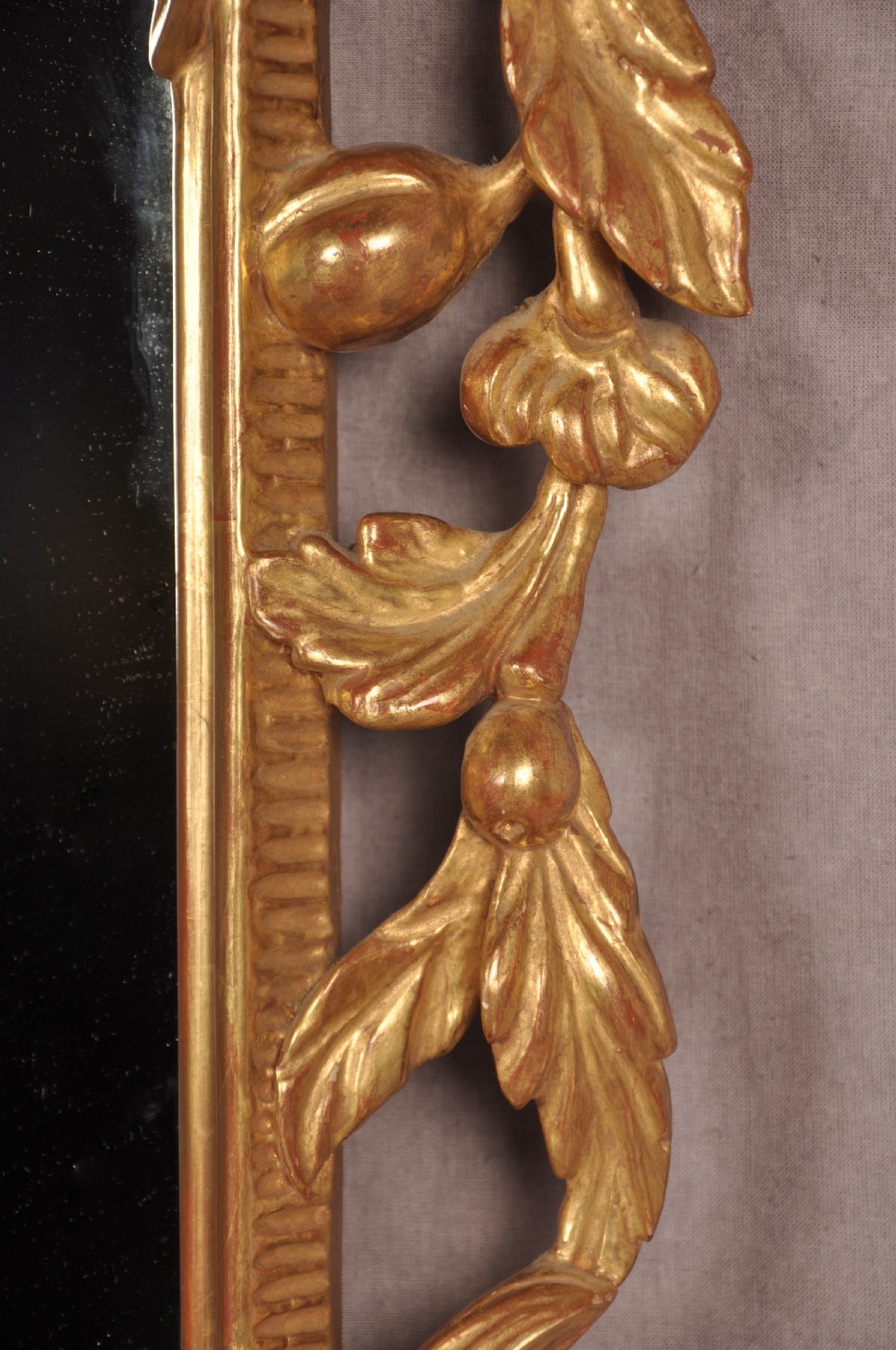 An ornate late nineteenth-century giltwood wall mirror featuring carved acanthus leaf scrollwork and an arched mirror plate. View VII