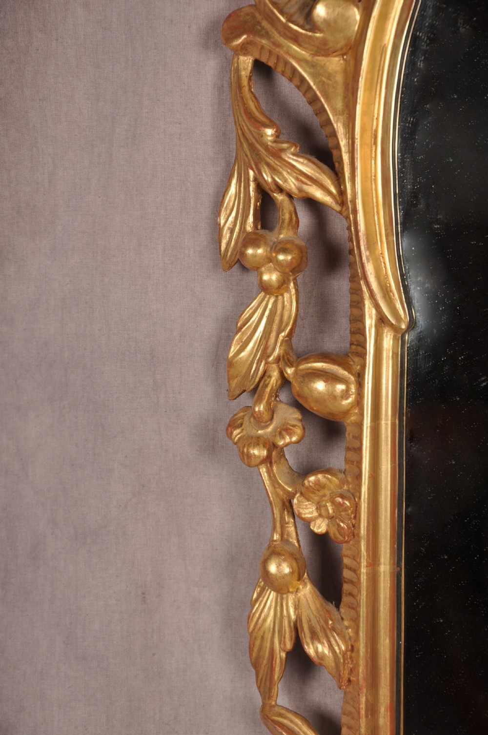 An ornate late nineteenth-century giltwood wall mirror featuring carved acanthus leaf scrollwork and an arched mirror plate. View VIII