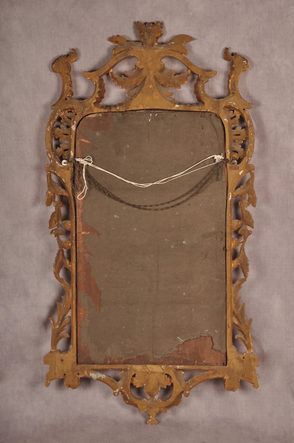 An ornate late nineteenth-century giltwood wall mirror featuring carved acanthus leaf scrollwork and an arched mirror plate. View IX