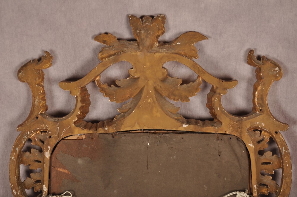 An ornate late nineteenth-century giltwood wall mirror featuring carved acanthus leaf scrollwork and an arched mirror plate. View X