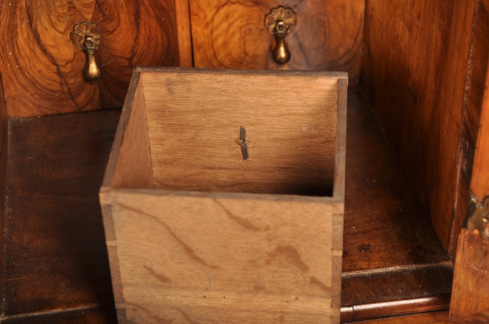 A 17th-century olive wood cabinet on stand featuring double doors inlaid with oval oyster veneer medallions, a lower drawer, turned legs, stretchers, and ball feet. View VI
