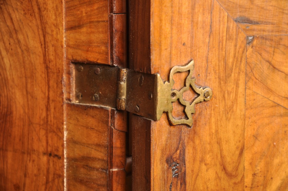 A 17th-century olive wood cabinet on stand featuring double doors inlaid with oval oyster veneer medallions, a lower drawer, turned legs, stretchers, and ball feet. View VIII
