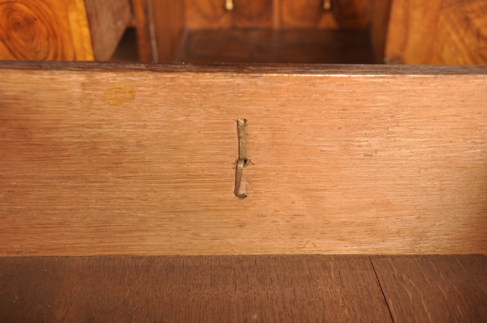 A 17th-century olive wood cabinet on stand featuring double doors inlaid with oval oyster veneer medallions, a lower drawer, turned legs, stretchers, and ball feet. View X