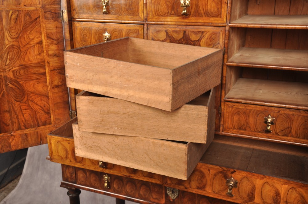 A 17th-century olive wood cabinet on stand featuring double doors inlaid with oval oyster veneer medallions, a lower drawer, turned legs, stretchers, and ball feet. View XI