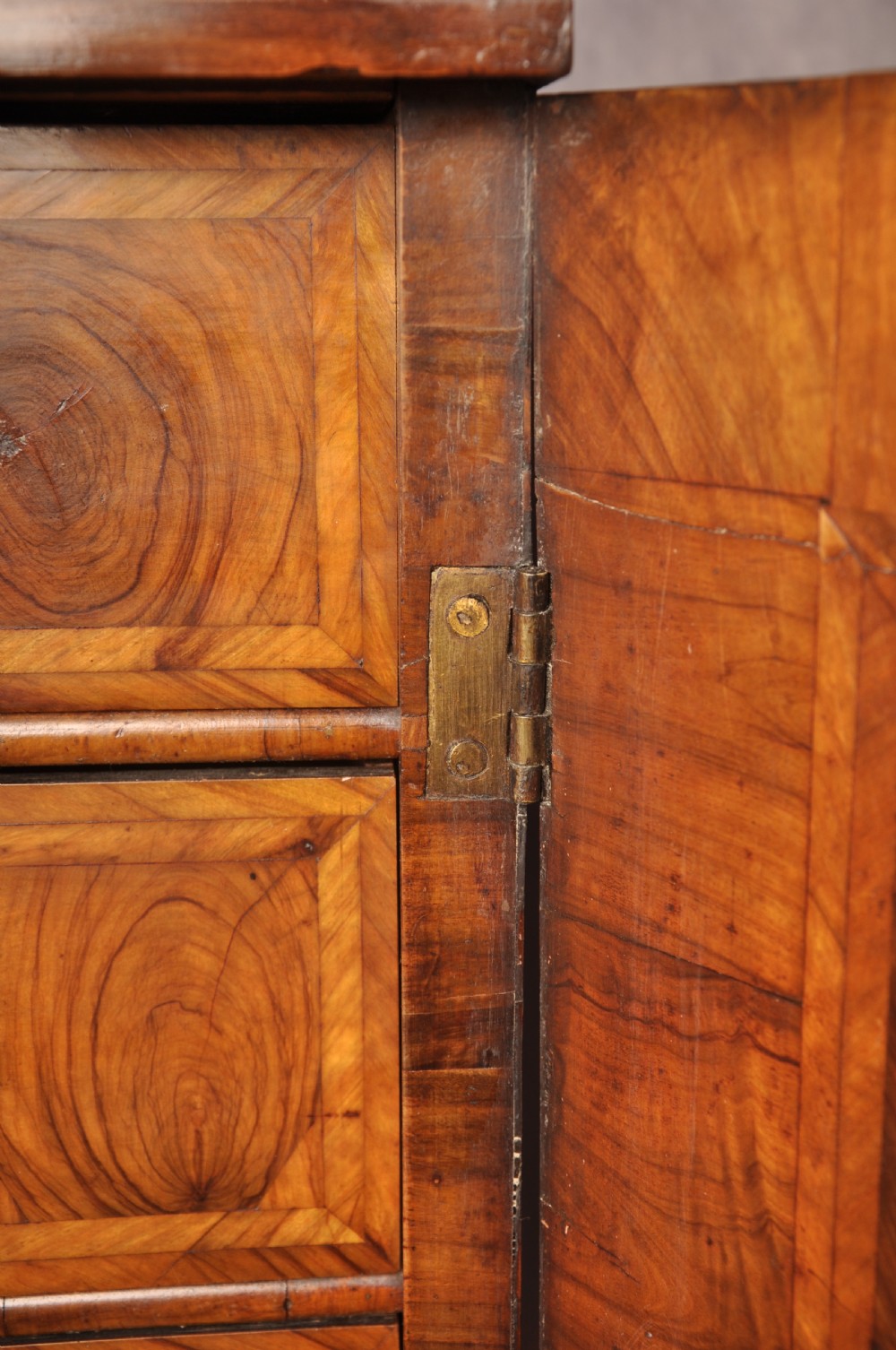 A 17th-century olive wood cabinet on stand featuring double doors inlaid with oval oyster veneer medallions, a lower drawer, turned legs, stretchers, and ball feet. View XII