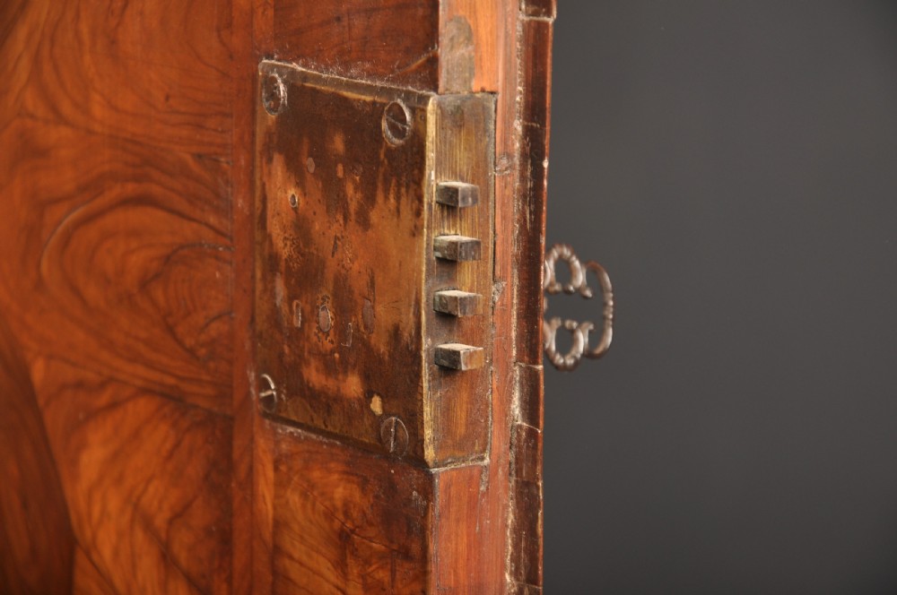 A 17th-century olive wood cabinet on stand featuring double doors inlaid with oval oyster veneer medallions, a lower drawer, turned legs, stretchers, and ball feet. View XIII