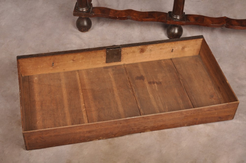 A 17th-century olive wood cabinet on stand featuring double doors inlaid with oval oyster veneer medallions, a lower drawer, turned legs, stretchers, and ball feet. View XVI