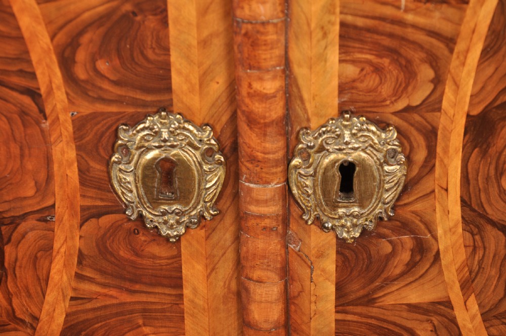 A 17th-century olive wood cabinet on stand featuring double doors inlaid with oval oyster veneer medallions, a lower drawer, turned legs, stretchers, and ball feet. View XXI