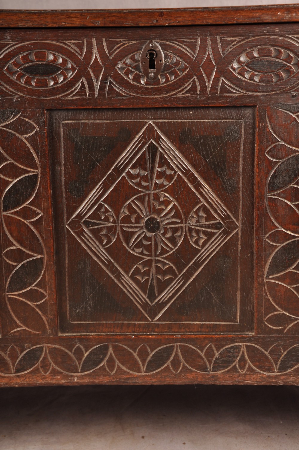 A 17th century carved oak coffer featuring three lozenge-carved front panels, leaf motifs, and ebonised detailing. View III