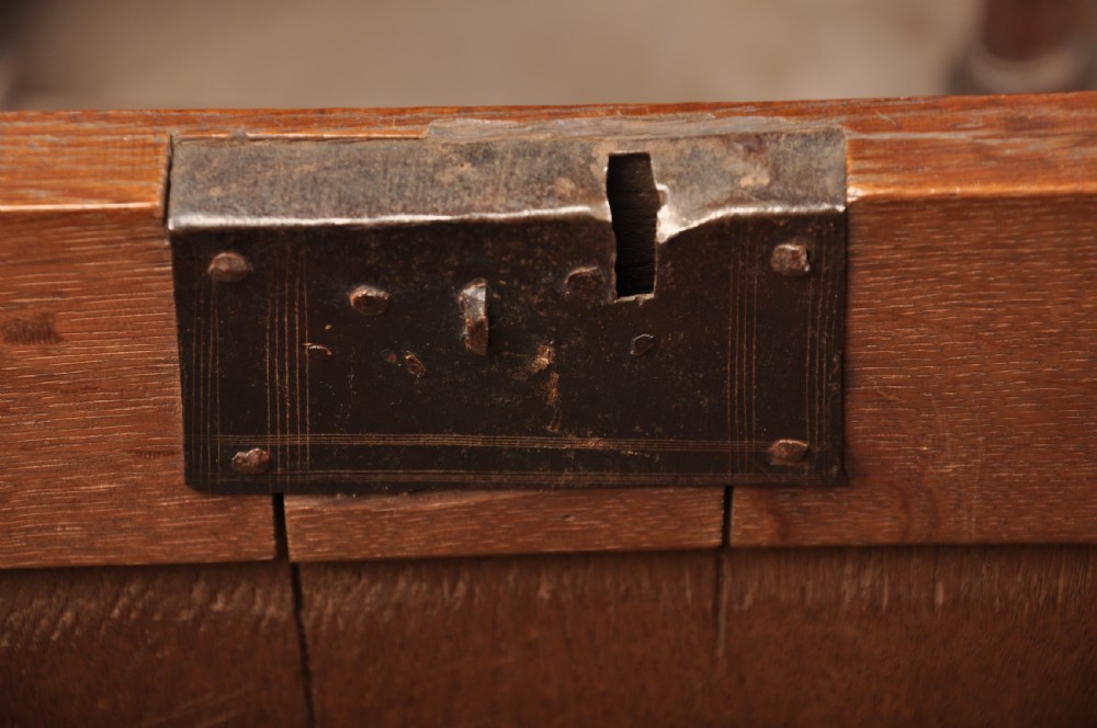 A 17th century carved oak coffer featuring three lozenge-carved front panels, leaf motifs, and ebonised detailing. View IX