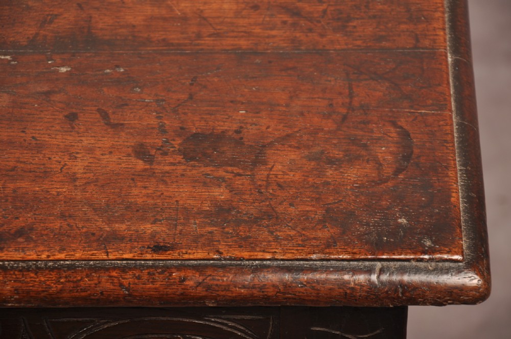A 17th century carved oak coffer featuring three lozenge-carved front panels, leaf motifs, and ebonised detailing. View XV