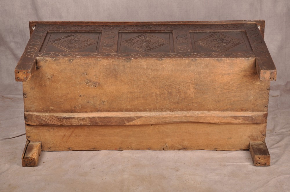 A 17th century carved oak coffer featuring three lozenge-carved front panels, leaf motifs, and ebonised detailing. View XVIII