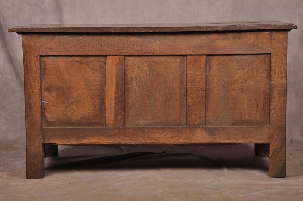 A 17th century carved oak coffer featuring three lozenge-carved front panels, leaf motifs, and ebonised detailing. View XIX