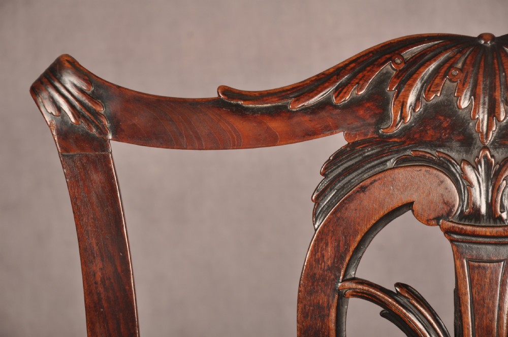 An 18th-century Chippendale carved mahogany armchair with a pierced splat, carved stretcher base, curved arms, and a warm brown leather seat. View IV