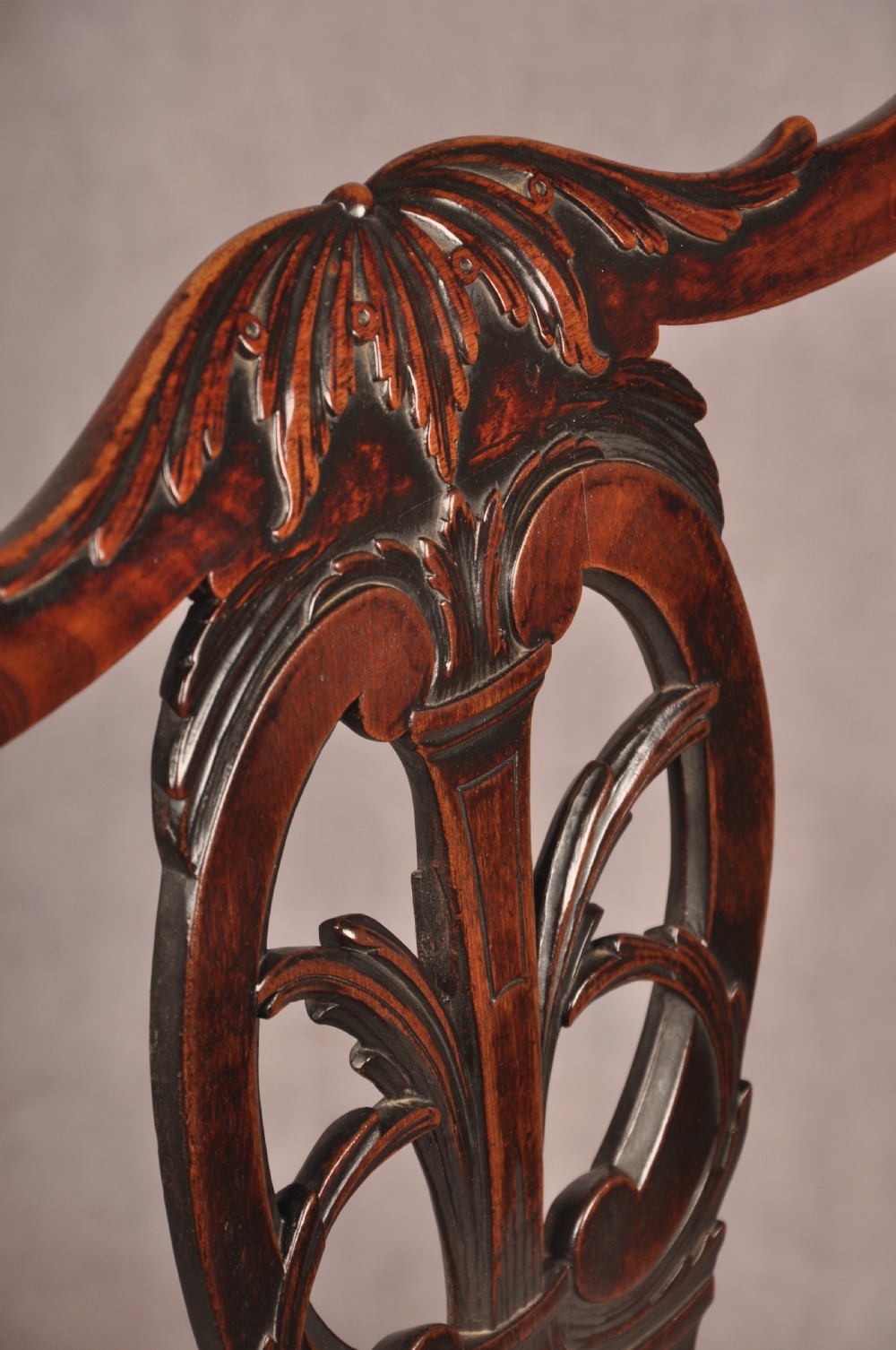 An 18th-century Chippendale carved mahogany armchair with a pierced splat, carved stretcher base, curved arms, and a warm brown leather seat. View XI