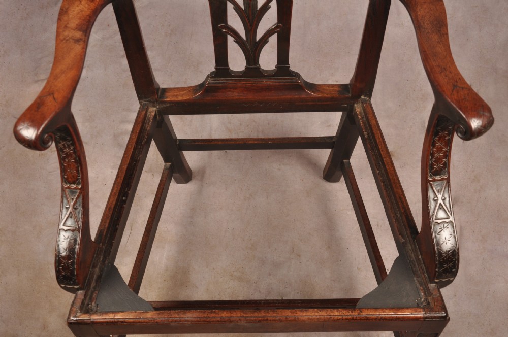 An 18th-century Chippendale carved mahogany armchair with a pierced splat, carved stretcher base, curved arms, and a warm brown leather seat. View XV