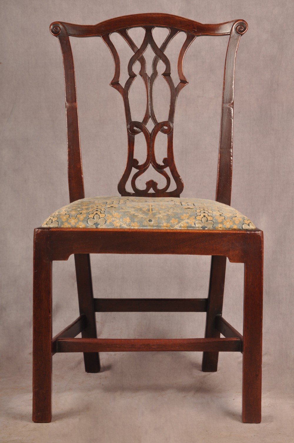 A set of six mahogany Chippendale style dining chairs featuring intricate pierced back splats and patterned upholstered drop-in seats. View IV