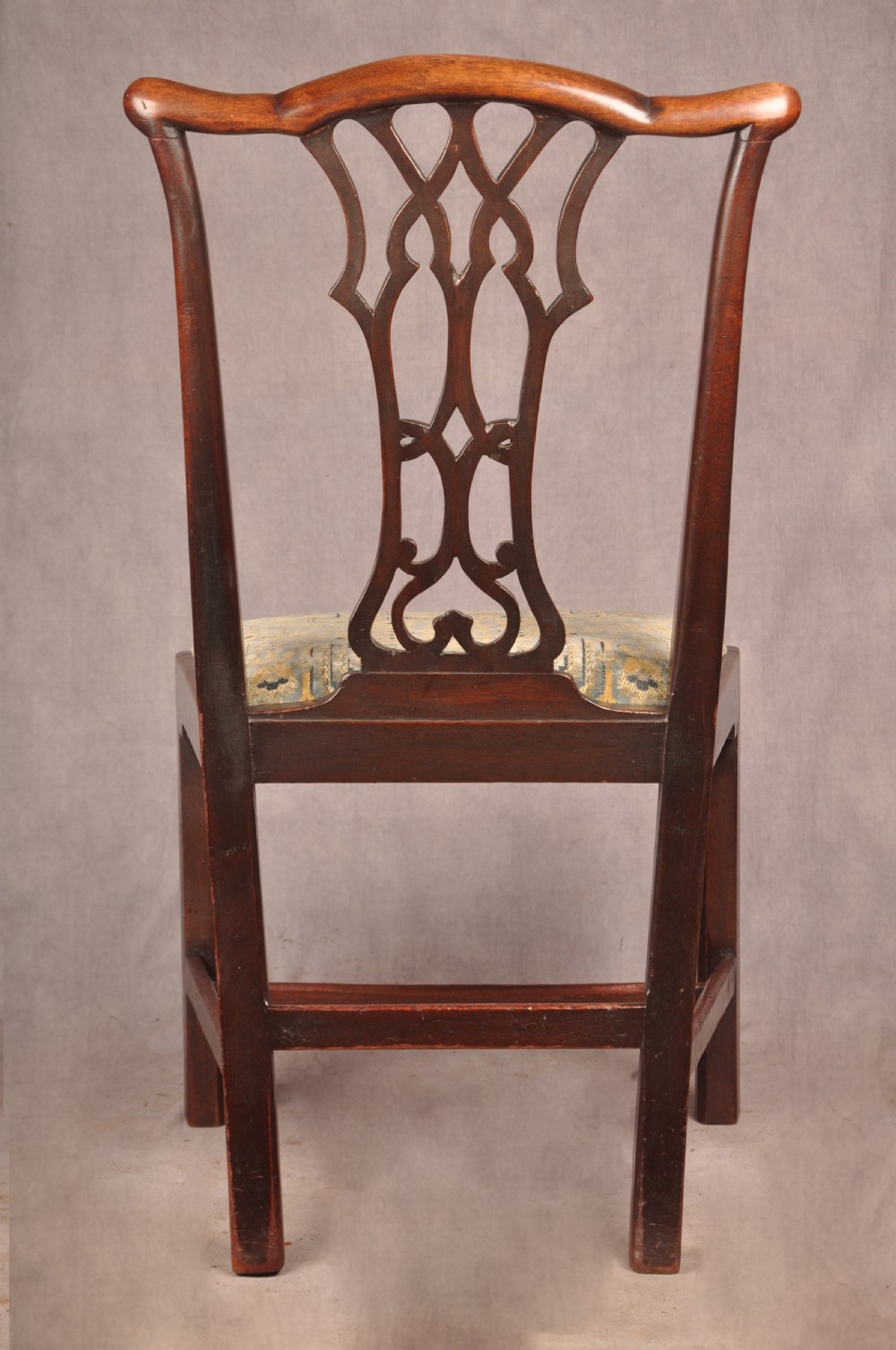 A set of six mahogany Chippendale style dining chairs featuring intricate pierced back splats and patterned upholstered drop-in seats. View VII