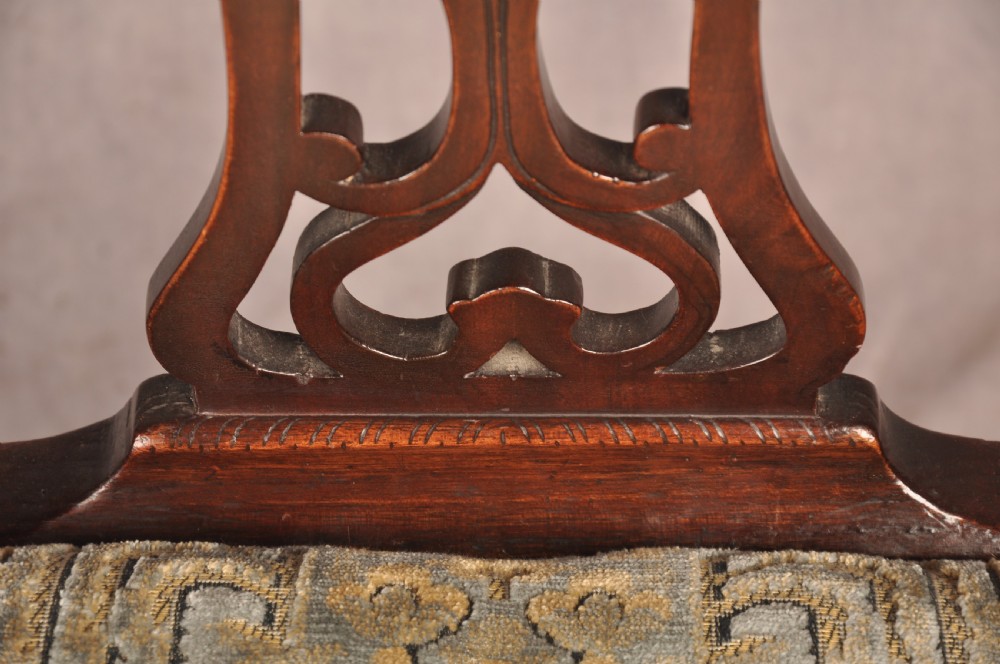 A set of six mahogany Chippendale style dining chairs featuring intricate pierced back splats and patterned upholstered drop-in seats. View X