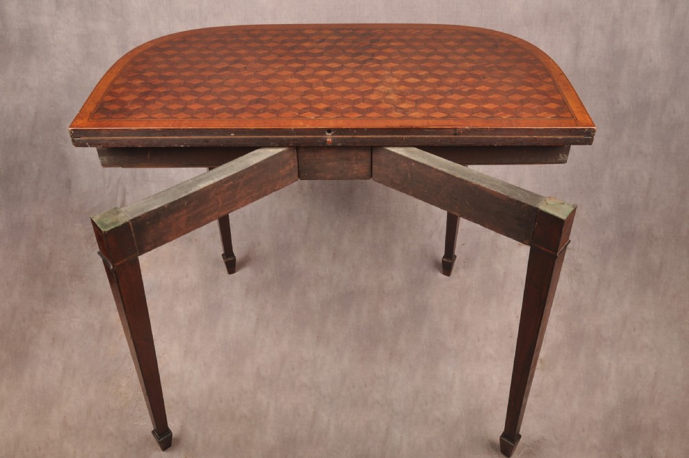 An 18th-century demilune card table featuring a geometric parquetry top, inlaid apron, and four square tapered legs ending in spade feet. View XI
