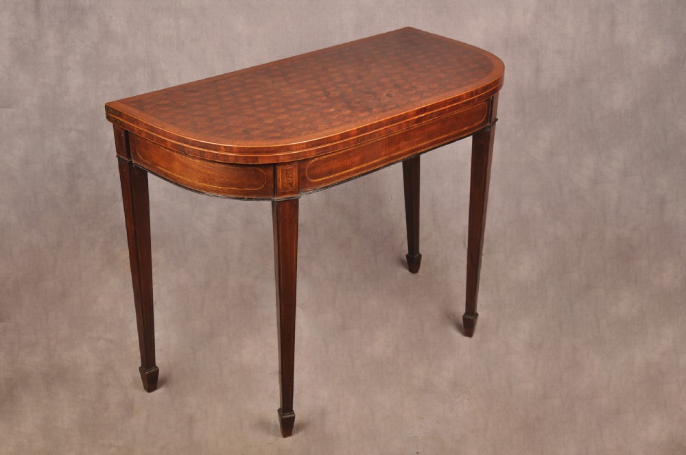 An 18th-century demilune card table featuring a geometric parquetry top, inlaid apron, and four square tapered legs ending in spade feet. View XII