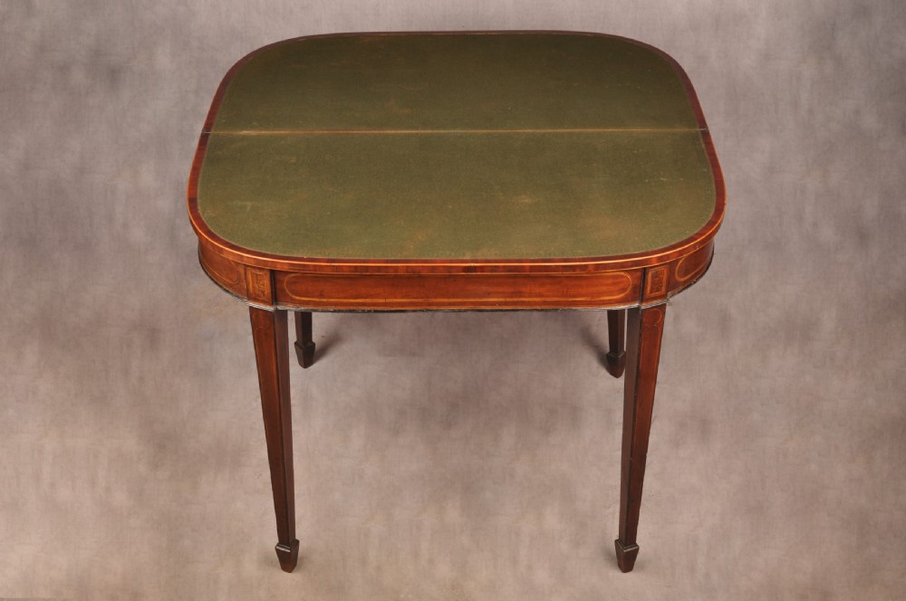 An 18th-century demilune card table featuring a geometric parquetry top, inlaid apron, and four square tapered legs ending in spade feet. View XV