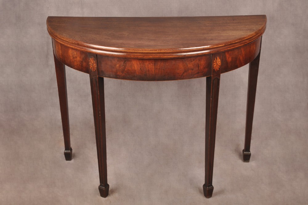 An 18th-century demilune mahogany tea table featuring tapered legs with inlaid patera motifs and spade feet. View II