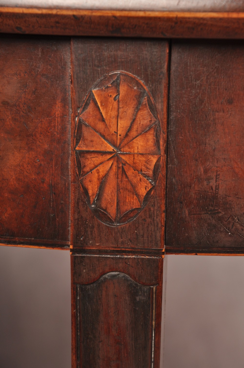 An 18th-century demilune mahogany tea table featuring tapered legs with inlaid patera motifs and spade feet. View III