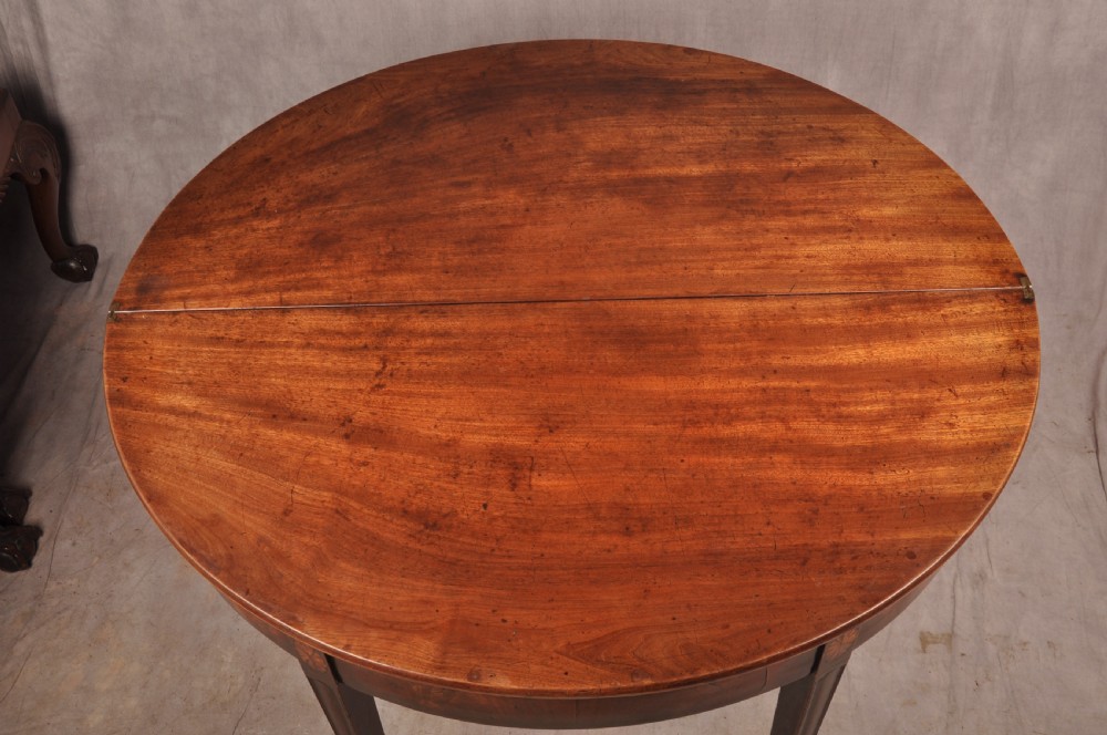 An 18th-century demilune mahogany tea table featuring tapered legs with inlaid patera motifs and spade feet. View VI
