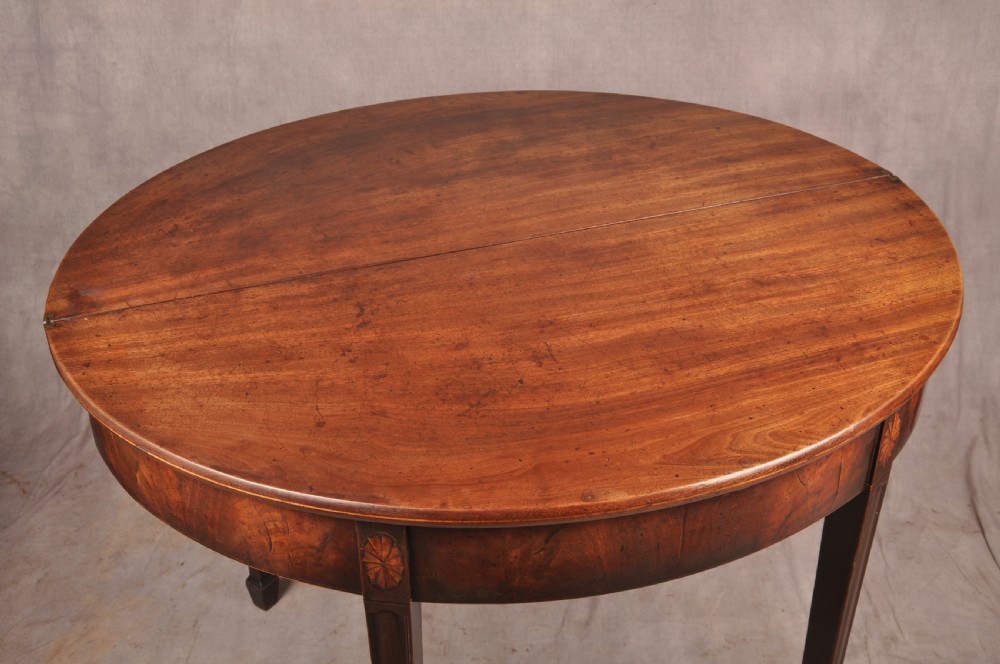 An 18th-century demilune mahogany tea table featuring tapered legs with inlaid patera motifs and spade feet. View VIII