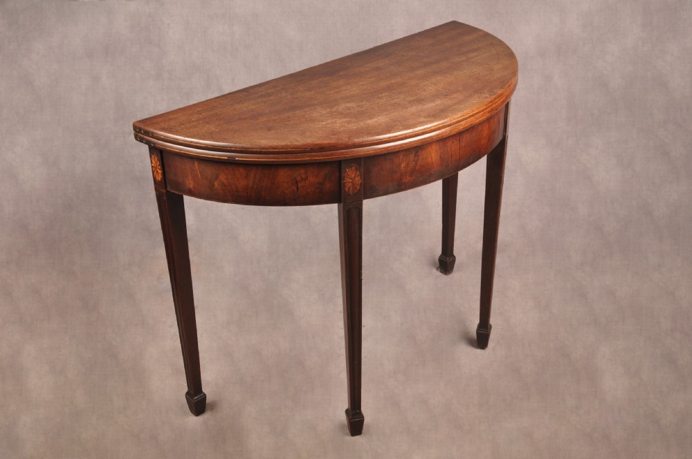 An 18th-century demilune mahogany tea table featuring tapered legs with inlaid patera motifs and spade feet. View IX