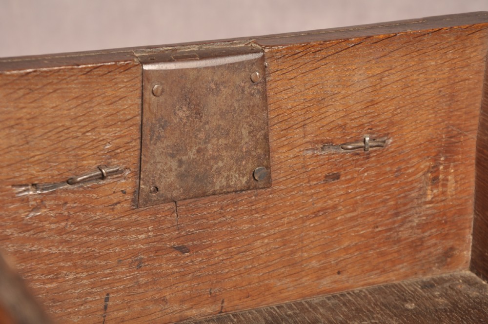 A Charles II dark oak chest of drawers featuring geometric moulded drawer panels, brass teardrop handles, keyhole escutcheons, and bun feet. View XIV