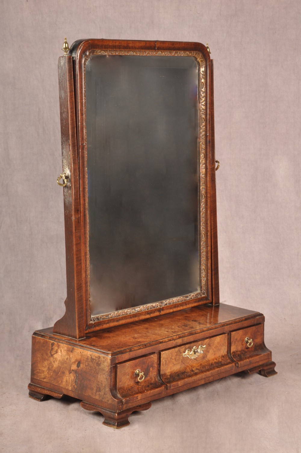 An 18th-century walnut toilet mirror featuring a rectangular adjustable glass frame resting above a three-drawer box base with brass handles. View II