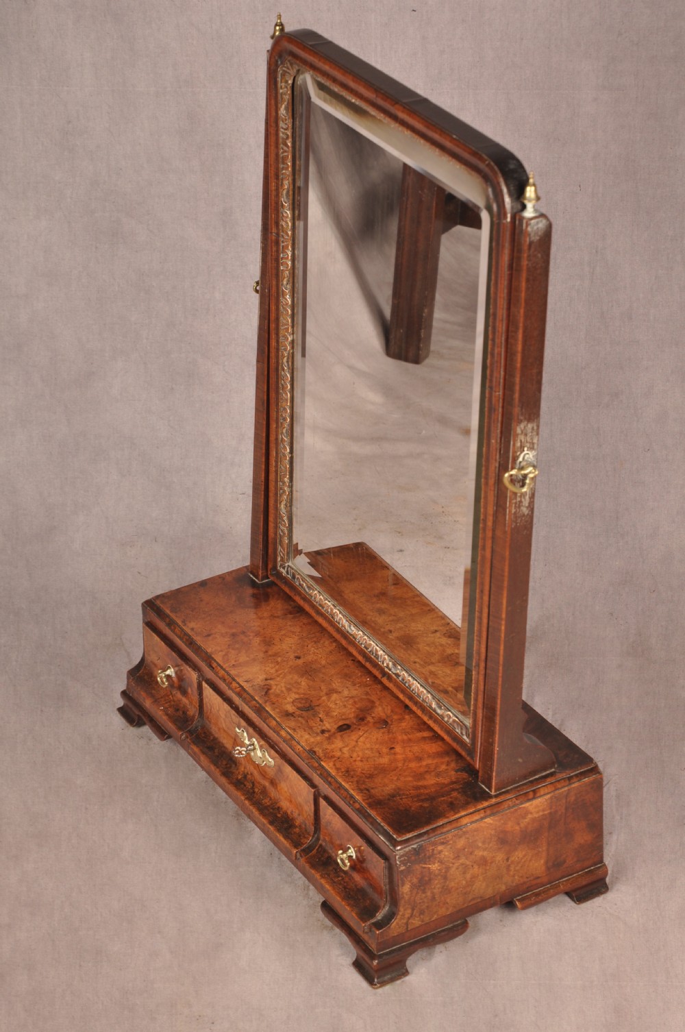 An 18th-century walnut toilet mirror featuring a rectangular adjustable glass frame resting above a three-drawer box base with brass handles. View III
