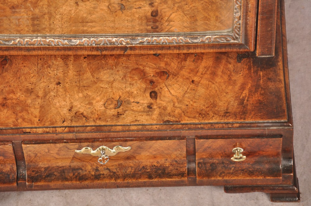 An 18th-century walnut toilet mirror featuring a rectangular adjustable glass frame resting above a three-drawer box base with brass handles. View VI
