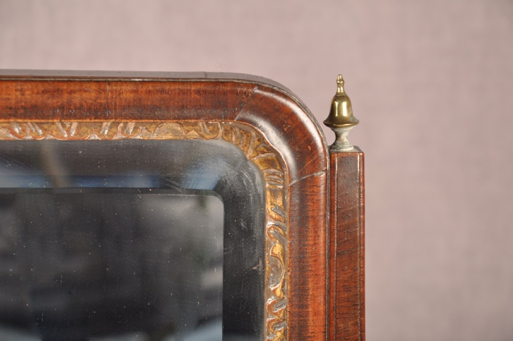 An 18th-century walnut toilet mirror featuring a rectangular adjustable glass frame resting above a three-drawer box base with brass handles. View X
