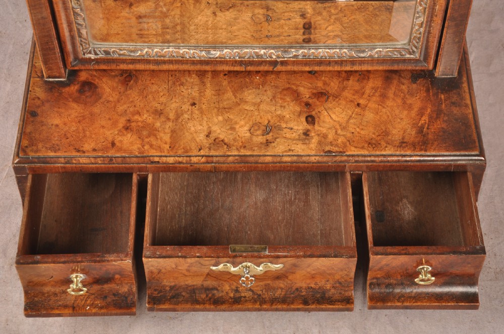 An 18th-century walnut toilet mirror featuring a rectangular adjustable glass frame resting above a three-drawer box base with brass handles. View XIII