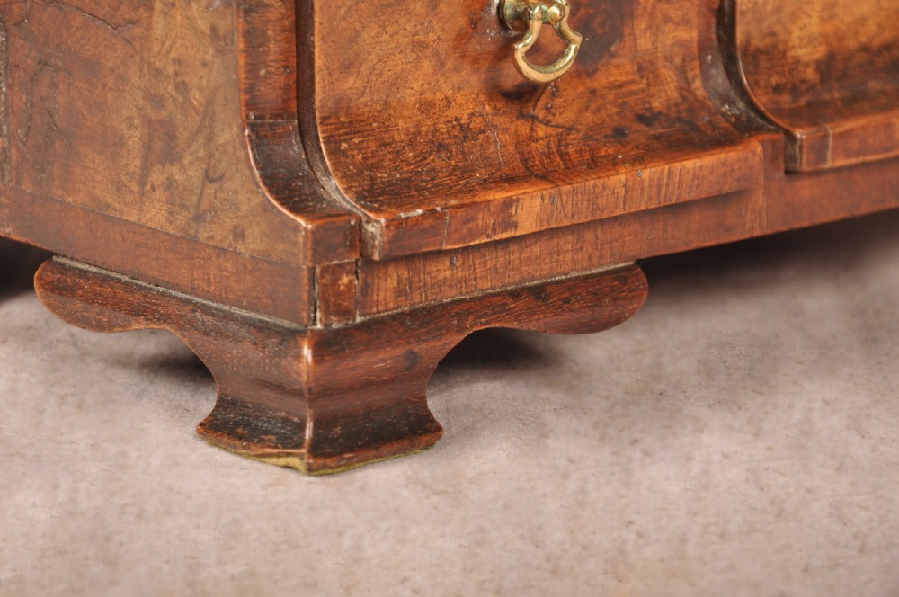 An 18th-century walnut toilet mirror featuring a rectangular adjustable glass frame resting above a three-drawer box base with brass handles. View XIV