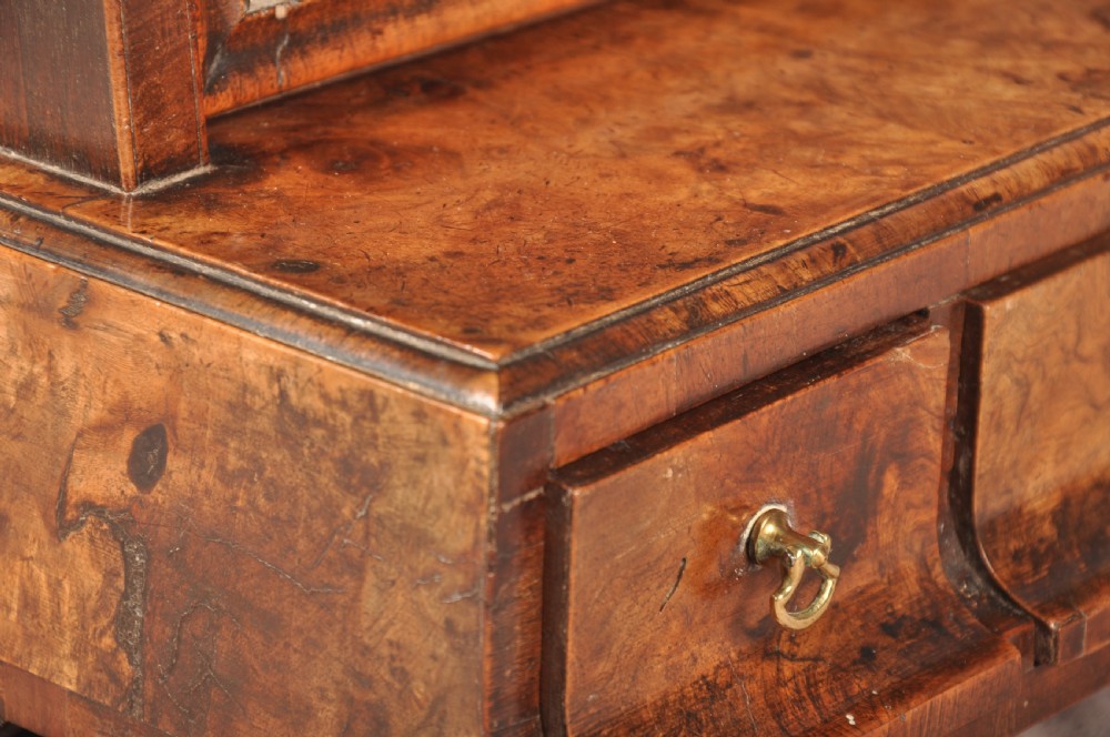 An 18th-century walnut toilet mirror featuring a rectangular adjustable glass frame resting above a three-drawer box base with brass handles. View XV