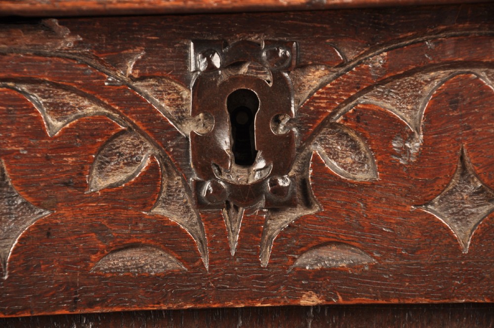 A 17th-century dark oak coffer with three carved arcaded front panels, an upper carved frieze, and a central iron lock plate. View III