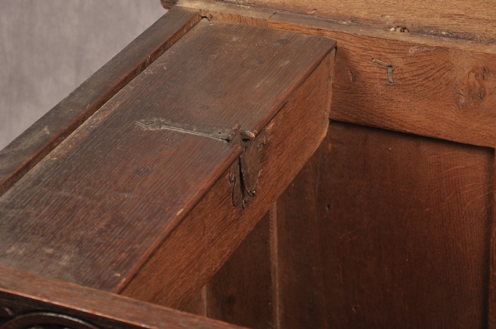 A 17th-century dark oak coffer with three carved arcaded front panels, an upper carved frieze, and a central iron lock plate. View VIII