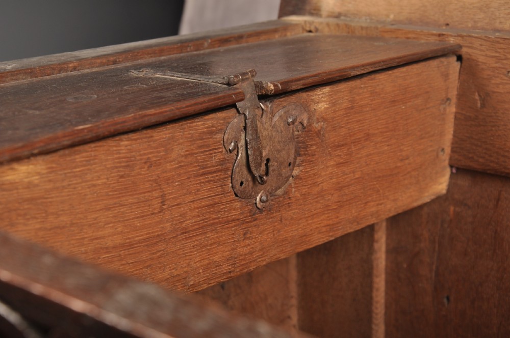 A 17th-century dark oak coffer with three carved arcaded front panels, an upper carved frieze, and a central iron lock plate. View IX