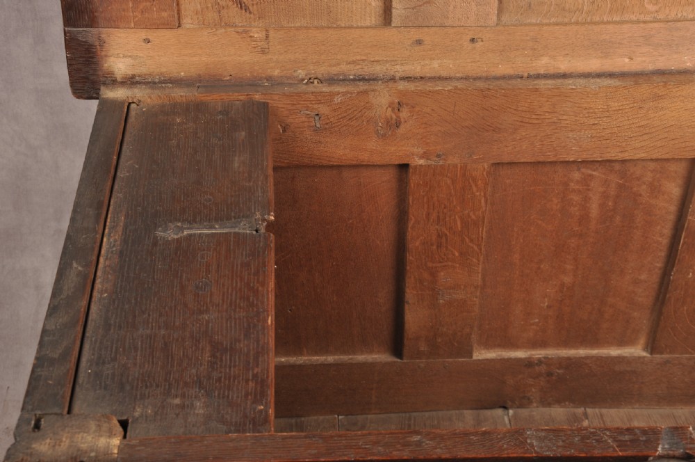 A 17th-century dark oak coffer with three carved arcaded front panels, an upper carved frieze, and a central iron lock plate. View X